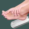 A hand is using a stainless steel foot file to remove calluses from the sole of the foot.