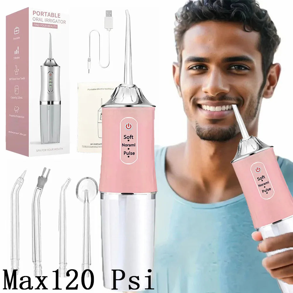 A man is holding a pink and silver portable oral irrigator device, demonstrating its use for dental cleaning.