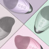 Three views of a USB rechargeable facial cleansing brush in various shades of purple, green, and pink.
