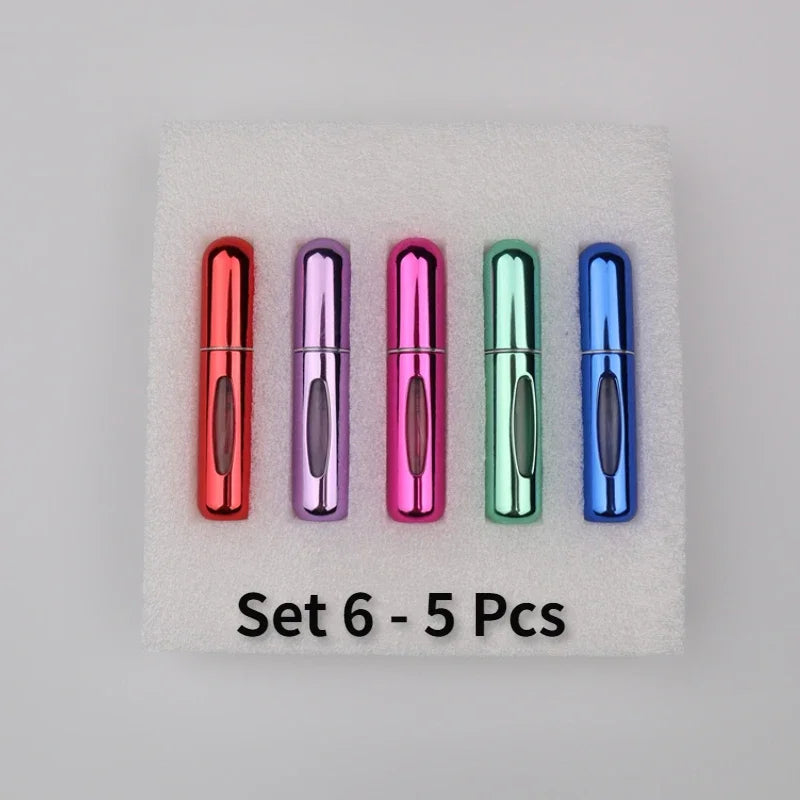 A set of five colorful 5ml travel perfume atomizer bottles arranged on a white foam pad.