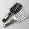 A black curved vented hair brush and a white paddle brush are shown on a light gray background.