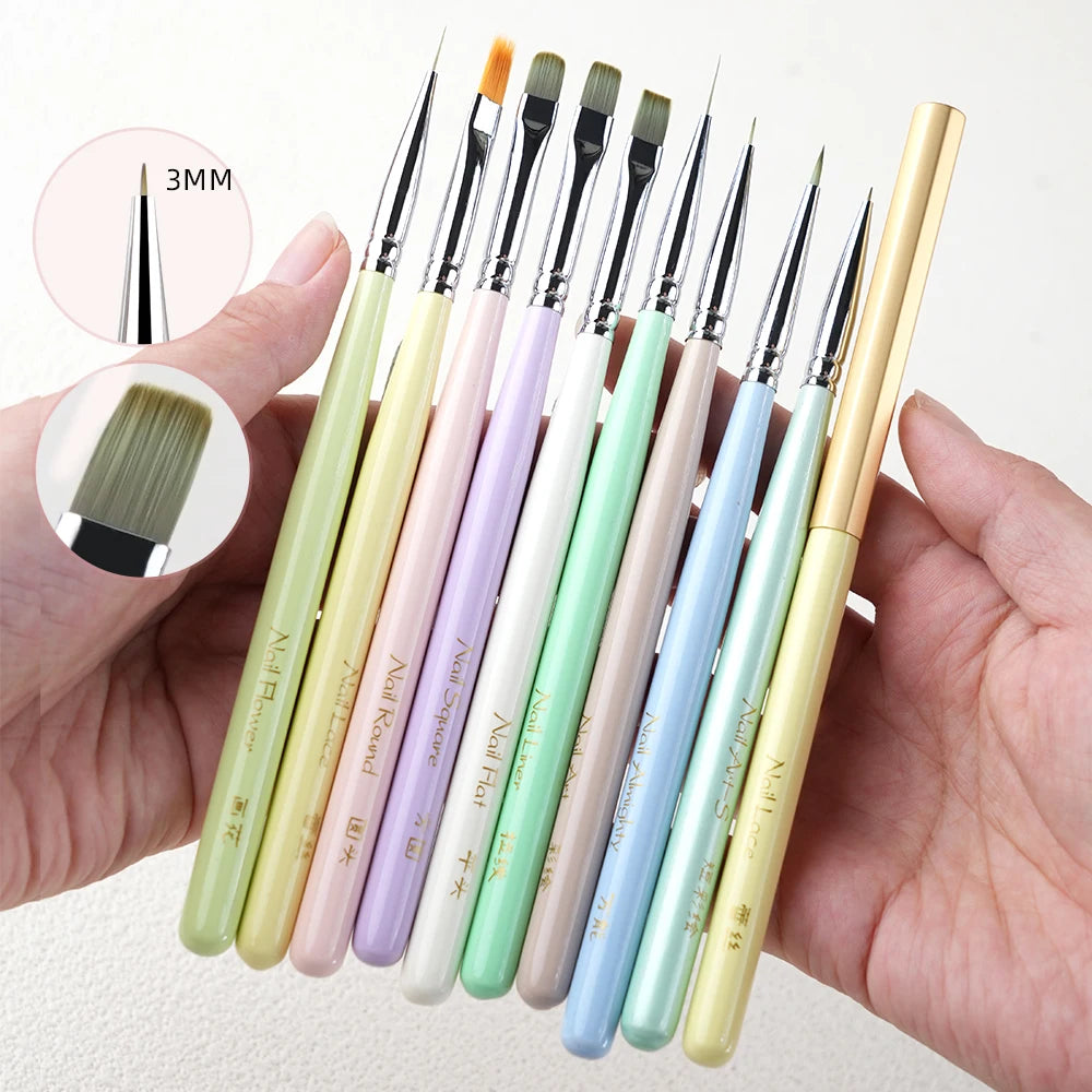 A hand holds a set of professional nail art brushes with various sizes and shapes in pastel colors.