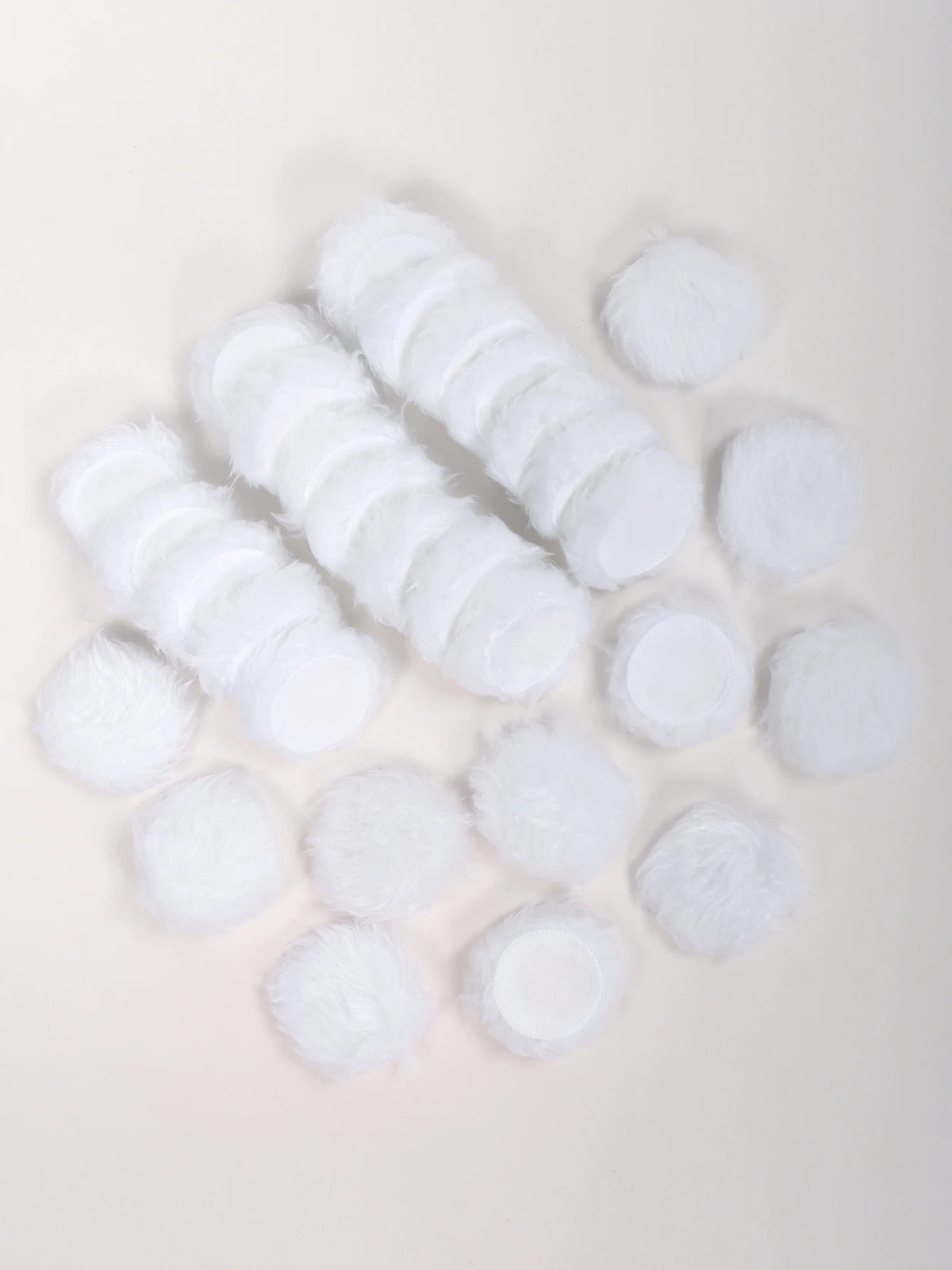 Una colección de esponjas para maquillaje blancas y esponjosas dispuestas sobre un fondo claro.