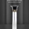 A silver electric hair clipper with a guard is displayed vertically on a dark surface.
