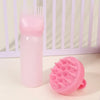 Un peigne applicateur de teinture capillaire en silicone rose à côté d'une brosse en caoutchouc silicone rose.