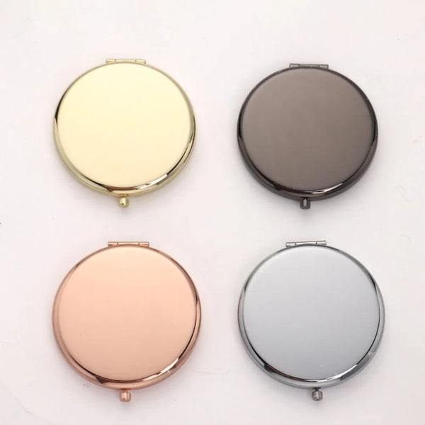 A set of four portable folding makeup mirrors in gold, silver, rose gold, and gray tones.