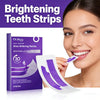 A woman smiles while holding a packet of brightening teeth strips for whitening.