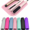 A pink silicone mat holds various hair styling tools including a curling iron and a brush with different colored silicone hai