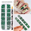 Un set de diamantes y adornos para uñas en verde y plata, mostrados con un lápiz en una mano.