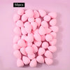 A set of 50 pink, oval-shaped soft makeup sponges arranged on a light pink background.