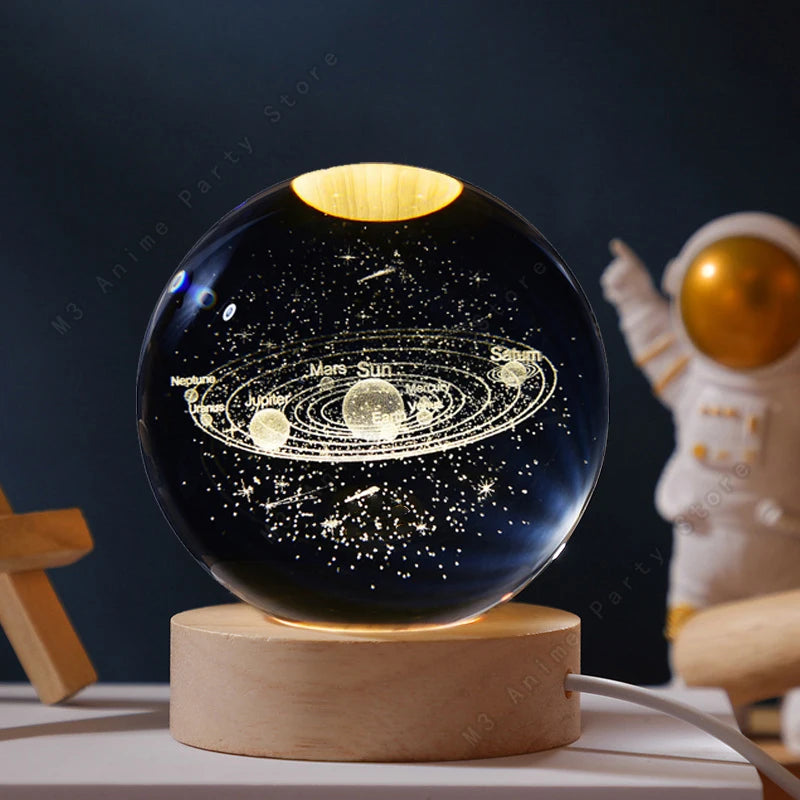 A spherical crystal ball night light displaying a solar system with planets and Saturn against a dark background.