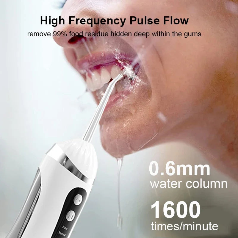 A close-up of a person using a portable electric oral irrigator to clean deep within the gums.