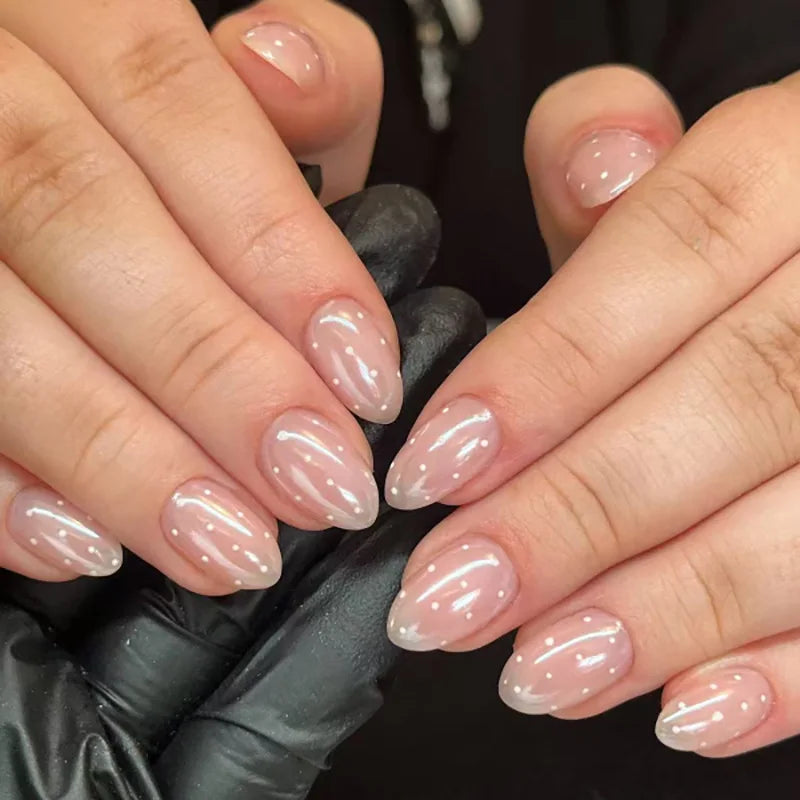Gros plan de mains montrant des ongles press-on roses à l'amande française sur les doigts