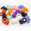 A collection of colorful silicone ear plugs in various shapes and colors scattered on a white background.
