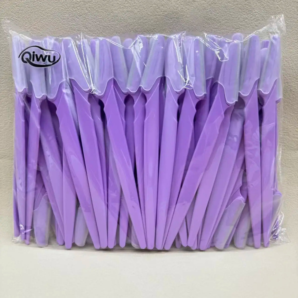 Un paquet de bandes de tondeuse à sourcils violettes dans un sac en plastique transparent.
