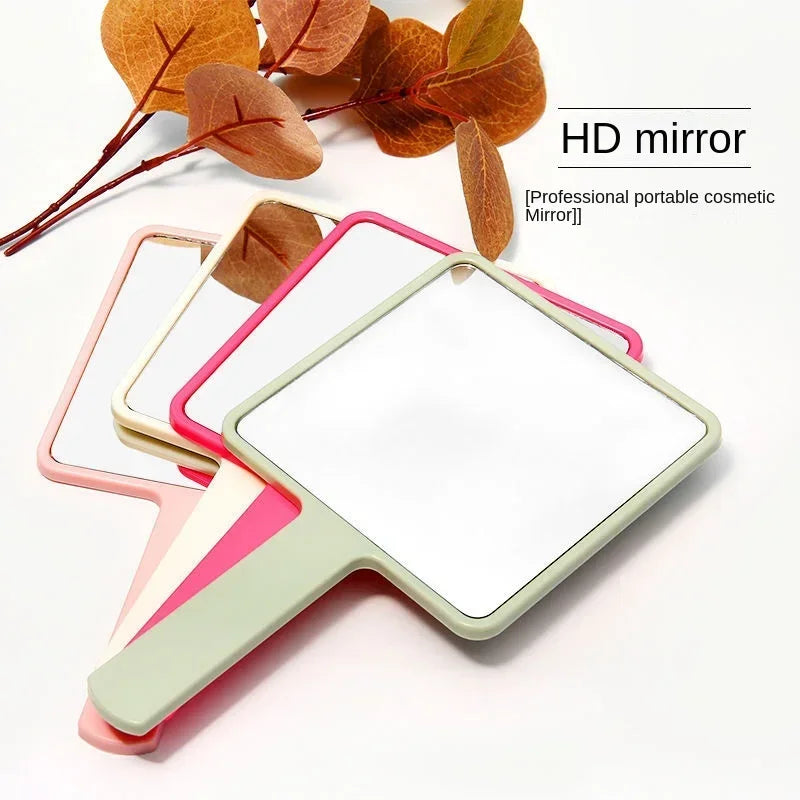 Miroir HD avec cadre vert clair et accents roses, à côté de feuilles d'automne.