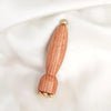 A natural wood facial and scalp massage comb with gold accents.