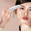 A woman gently scrapes her eyebrow appearance using a white electric shaver and trimmer device.