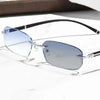 A pair of silver-framed photochromic reading glasses resting on a white marble surface.