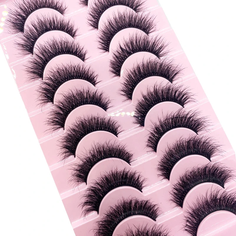 Un plateau en plastique rose contenant plusieurs paires de faux cils de renfort en mink noirs.