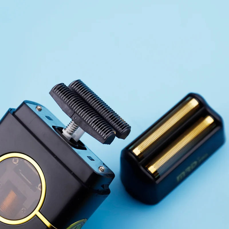 Primer plano de un cortapelos eléctrico negro con cabeza recortadora desmontable sobre un fondo azul claro.