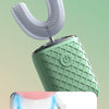 A close-up view of a green electric toothbrush with a white brush head, showing different tooth contours and brush types.