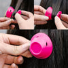 A set of bright pink heatless silicone curling hair tools being used to curl dark hair.