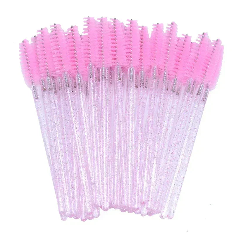 A set of pink disposable eyelash and eyebrow brushes with silver accents.