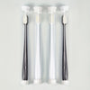 Three clear tubes of ultra-soft microbristle toothbrushes with white handles displayed vertically.