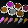 A collection of round containers filled with various shades of holographic chrome nail glitter powder.