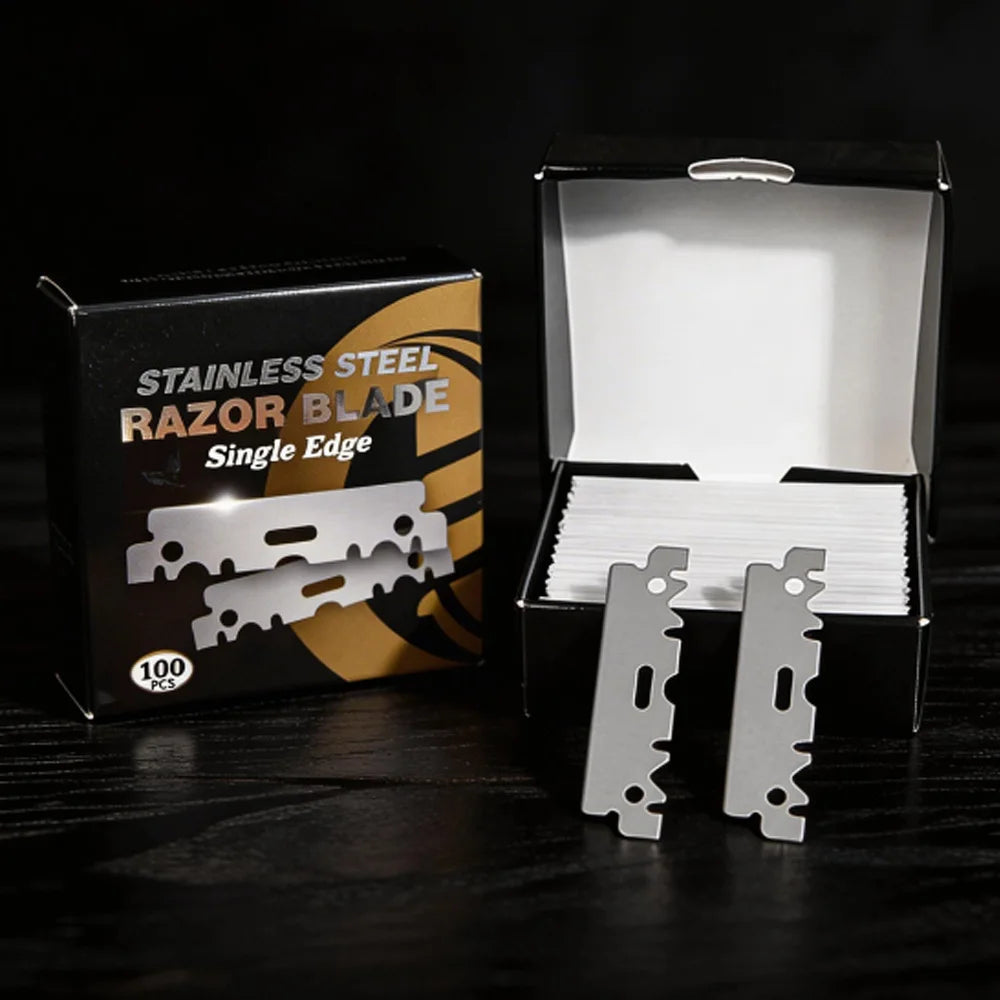 A black box containing single edge stainless steel razor blades with a silver blade visible inside.