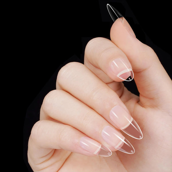 A hand holds a set of press-on nail tips with various clear and nude shapes on a black background.
