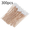 A pile of 300 precision wooden cotton swabs with white tips arranged diagonally.