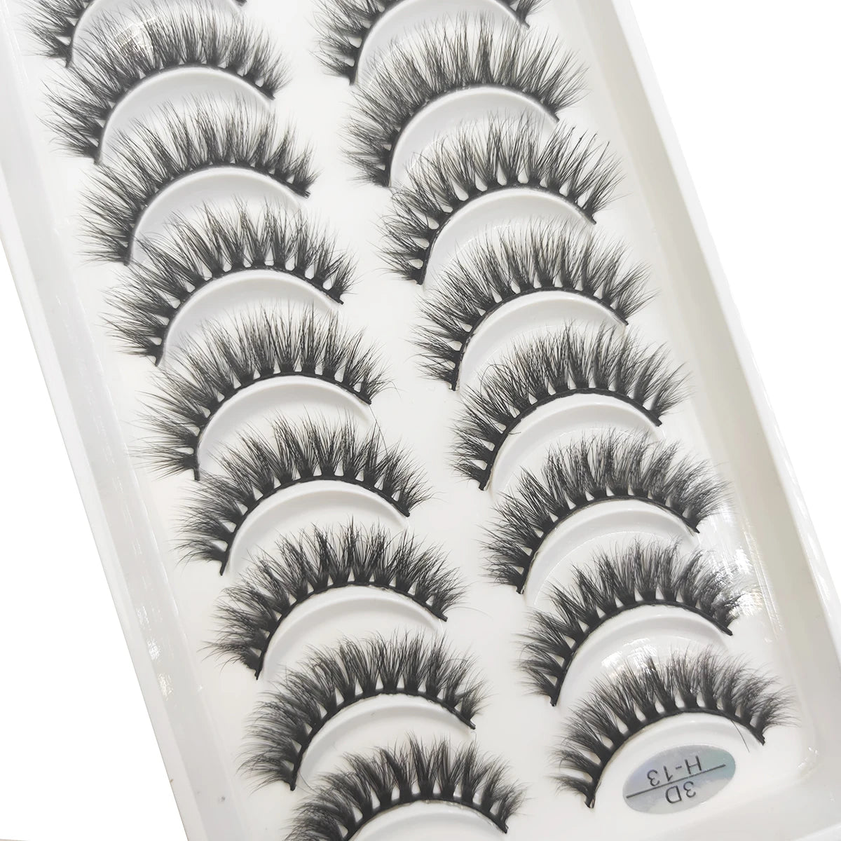 A tray of natural 3D mink false eyelashes displayed in a white plastic container.
