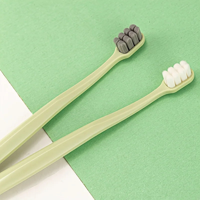 Une paire de brosses à dents vert clair à poils différents est exposée sur un fond vert.