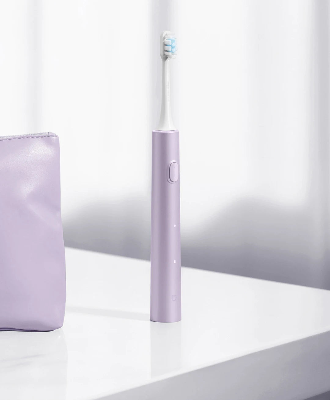 A purple sonic electric toothbrush with a white brush head stands on a white surface.