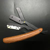 Mango de madera y cuchillas de metal negro de una maquinilla de afeitar manual profesional.