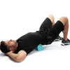A man lying on his back receiving a deep tissue massage treatment on his lower body with a muscle massager.