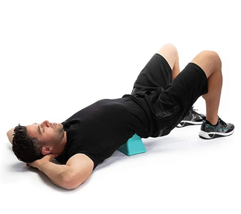 A man lying on his back receiving a deep tissue massage treatment on his lower body with a muscle massager.