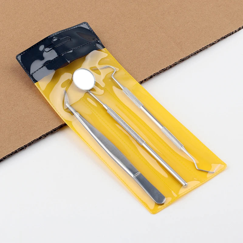 A stainless steel dental cleaning tool set in a yellow plastic case resting on brown cardboard.