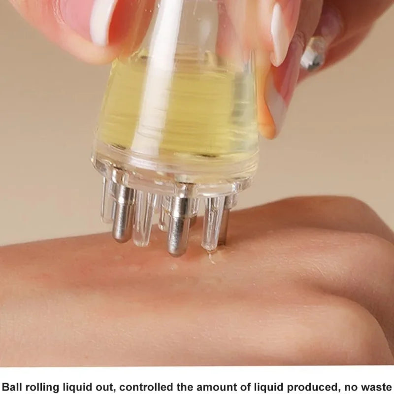 A hand is applying liquid from a precision scalp oil applicator bottle with a ball-tip massager onto the skin.