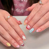 Close-up of hands displaying red pink striped press-on nails with almond shape and various designs
