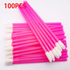 A set of 100 pink precision makeup brushes with white tips laid out on a pink surface.