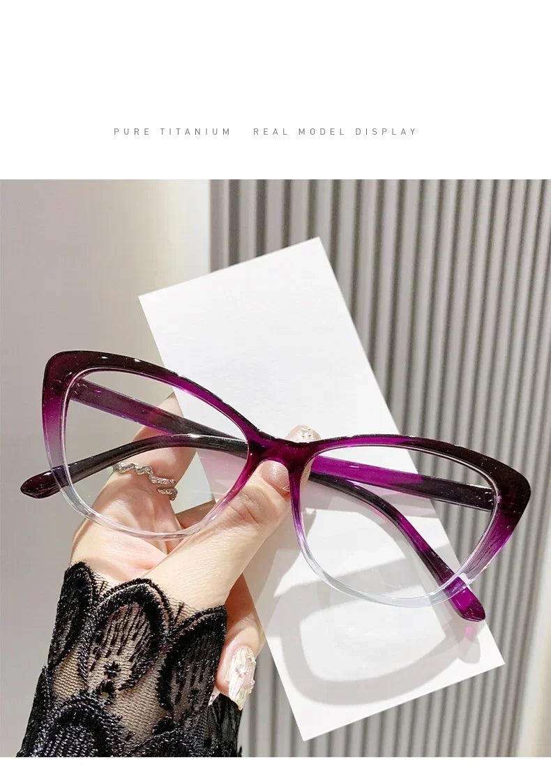 Purple cat eye reading glasses displayed on a white card against a gray background.