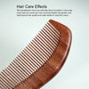 A close-up view of a reddish-brown wooden hair comb with parallel teeth.