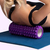 A purple fitness foam roller lying on a blue mat, positioned for muscle recovery.