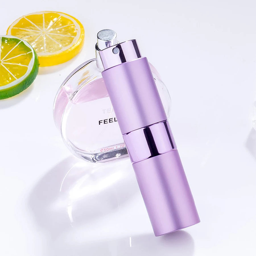 Bouteille de parfum en verre violet et atomiseur argenté assorti avec une tranche de citron.