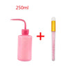 A pink cleaning bottle for eyelash extensions with a precision applicator brush and a cosmetic product.