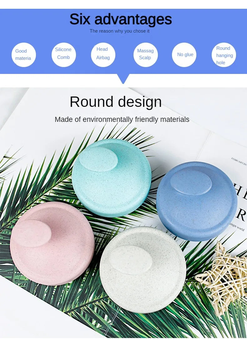 A set of round scalp massage brushes in various pastel colors, including blue, pink, and white, displayed on green palm leave
