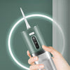 A hand holds a silver oral irrigator device with a white tip, demonstrating its use for deep cleaning.